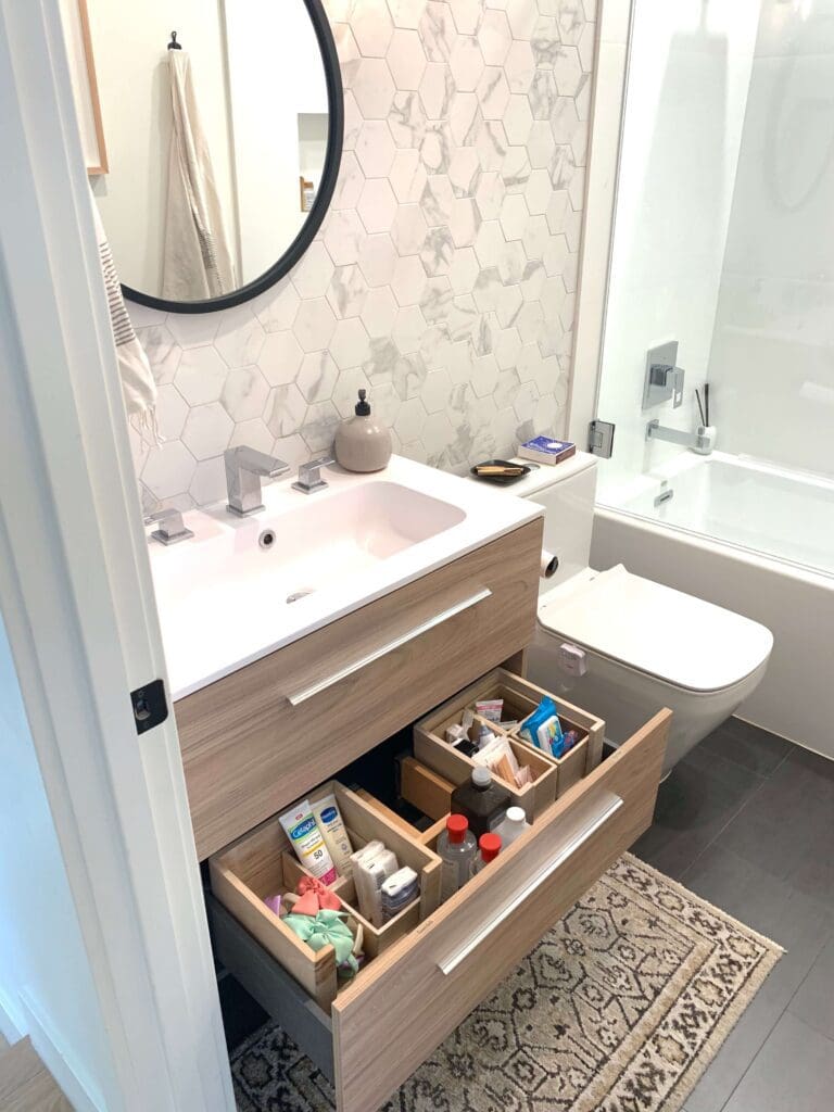 Simply Luxe bathroom vanity with open drawers of neatly organized toiletries