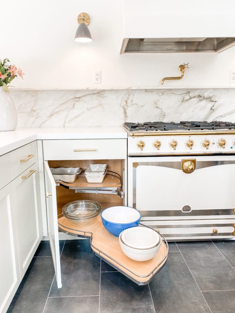 Bright kitchen corner with open cabinets displaying dishes and a vintage stove.