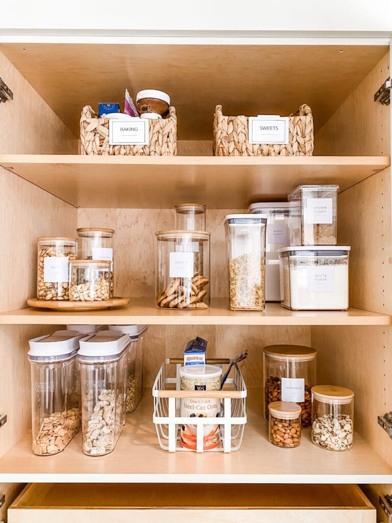 Organized pantry shelves with labeled jars and baskets.