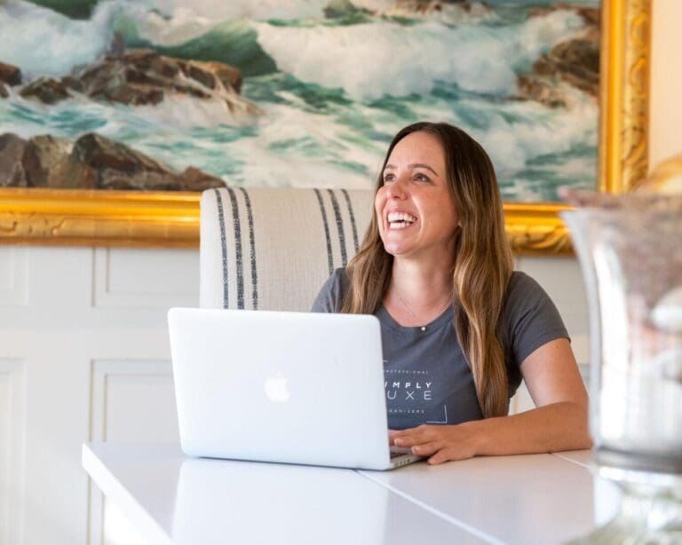Smiling woman working on a laptop.