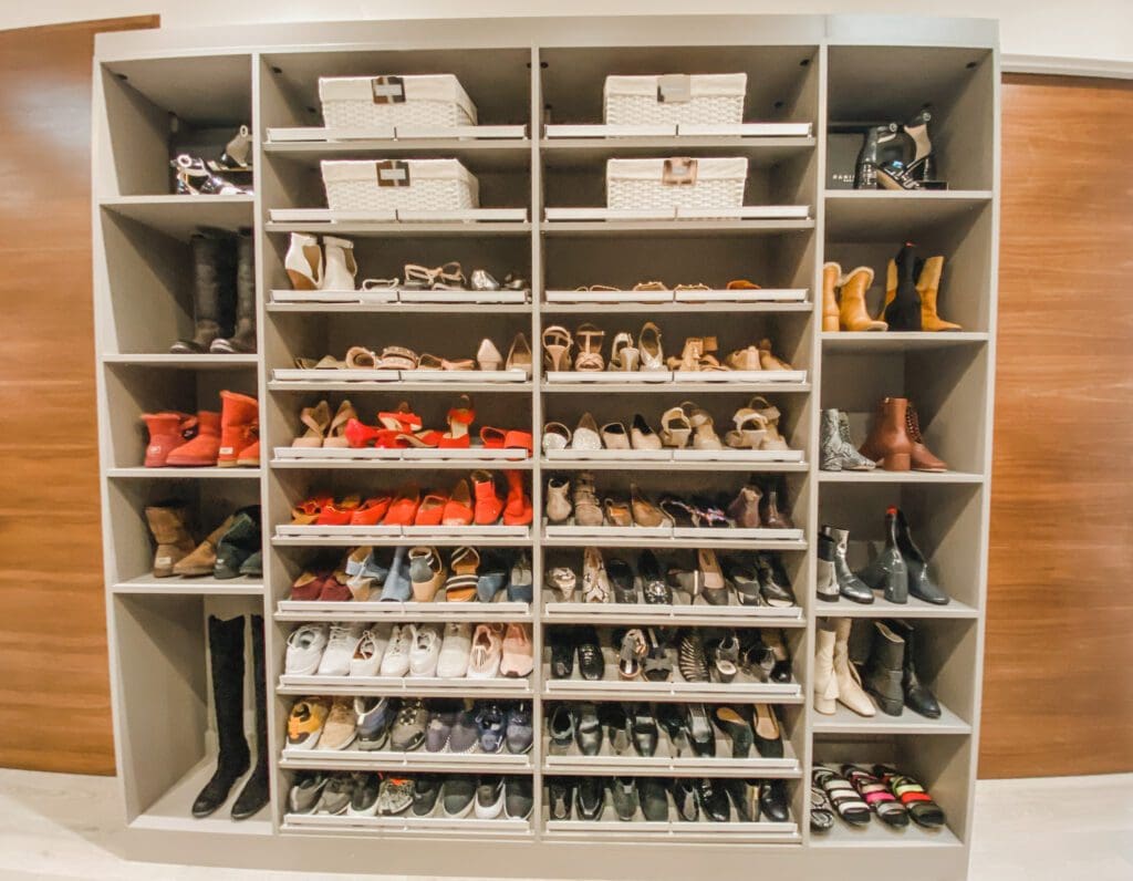 Organized shoe closet with various pairs of boots and heels.