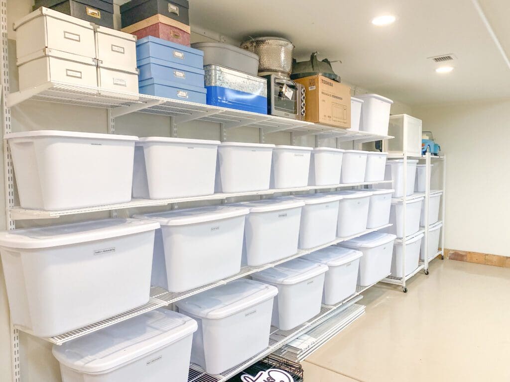 Neatly organized white storage bins stacked in rows on shelves in a clean room.