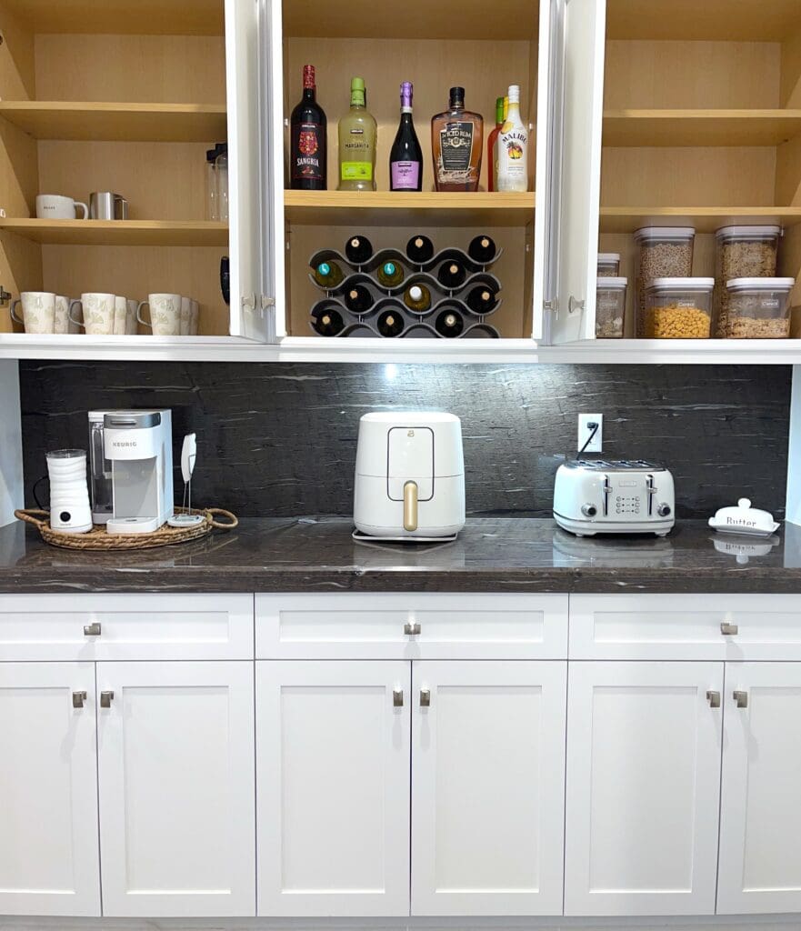 A clean kitchen counter with appliances and shelves.
