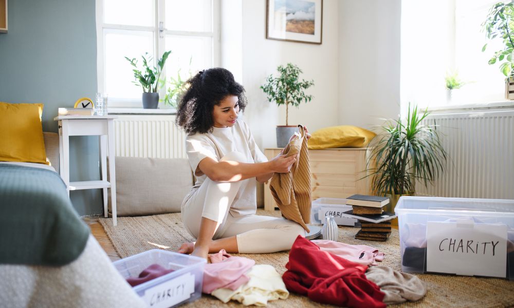 A Woman With Curly Hair Organizing Clothes