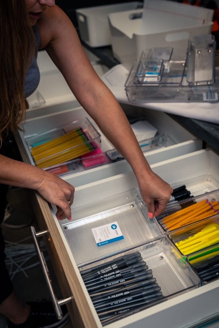 Organizer sorting pens and office supplies into a drawer organizer