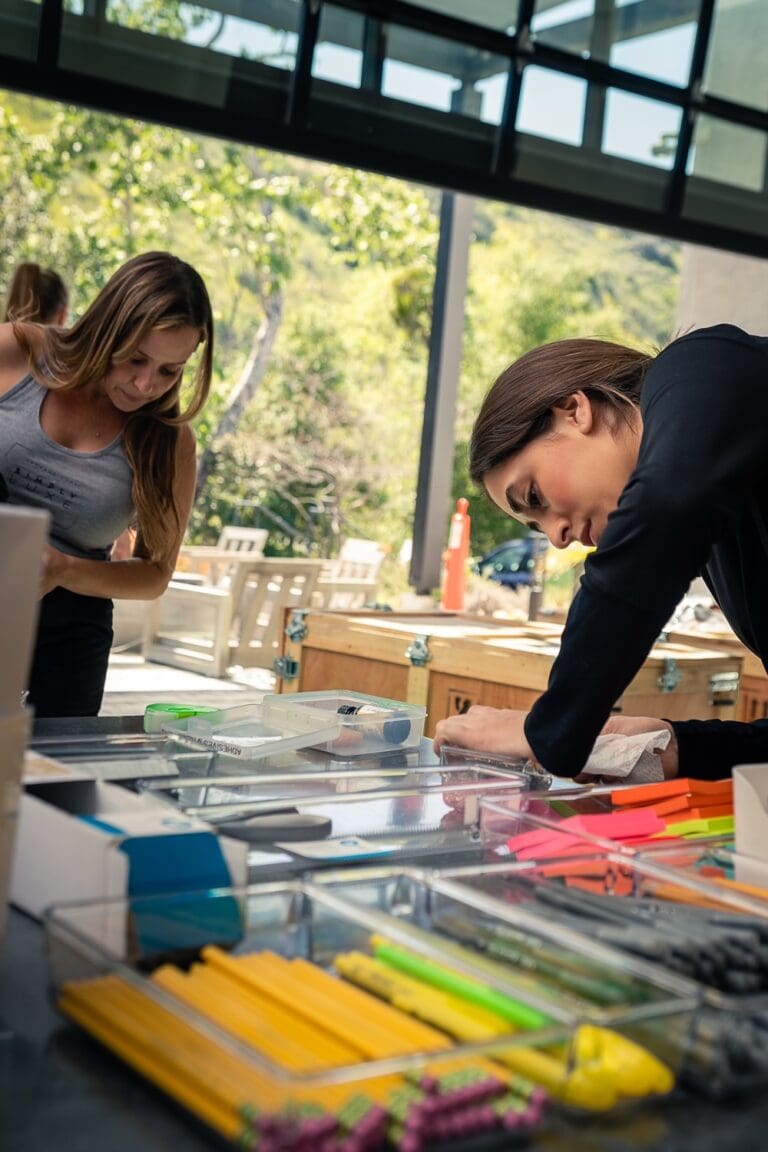 Two Simply Luxe organizers sorting colorful stationery on a work table