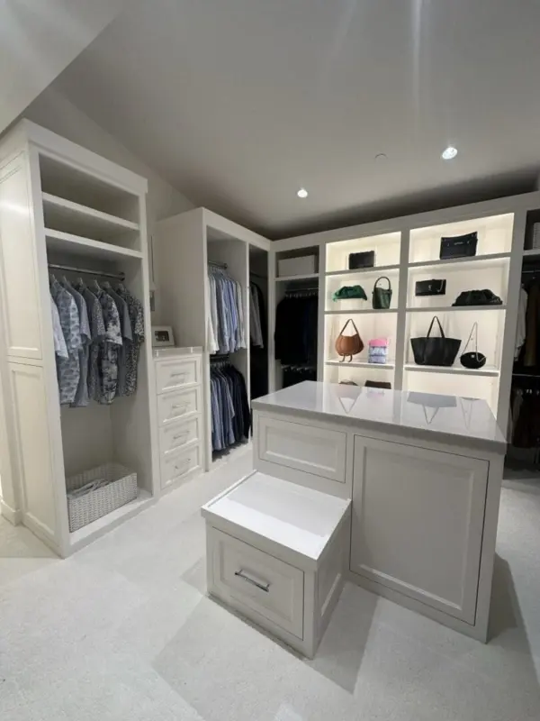 Walk-in closet with hanging clothes and shelves organized by Simply Luxe