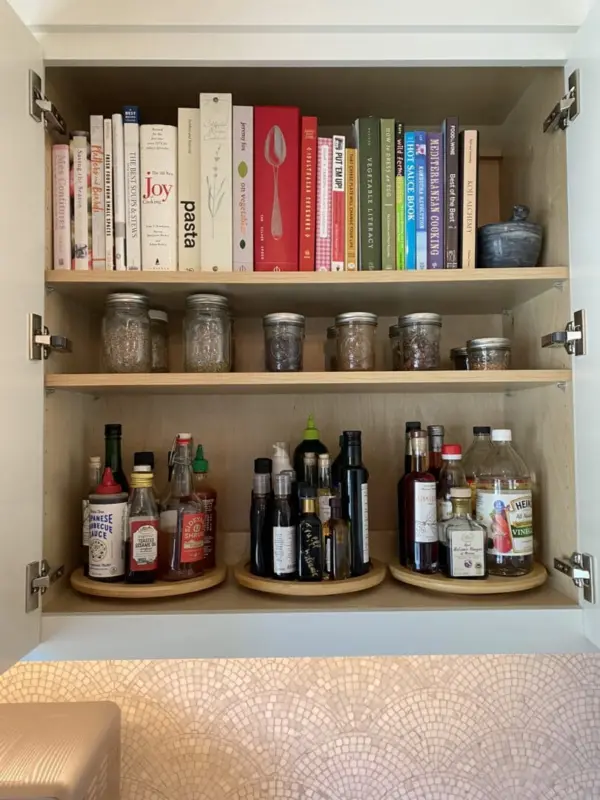 Kitchen cabinet with spices, sauces and condiments organized on wooden shelves