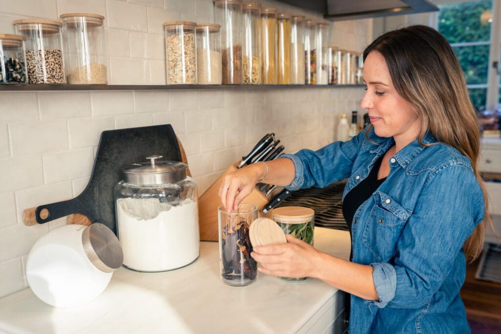Simply Luxe organizer using a pepper grinder in an organized kitchen