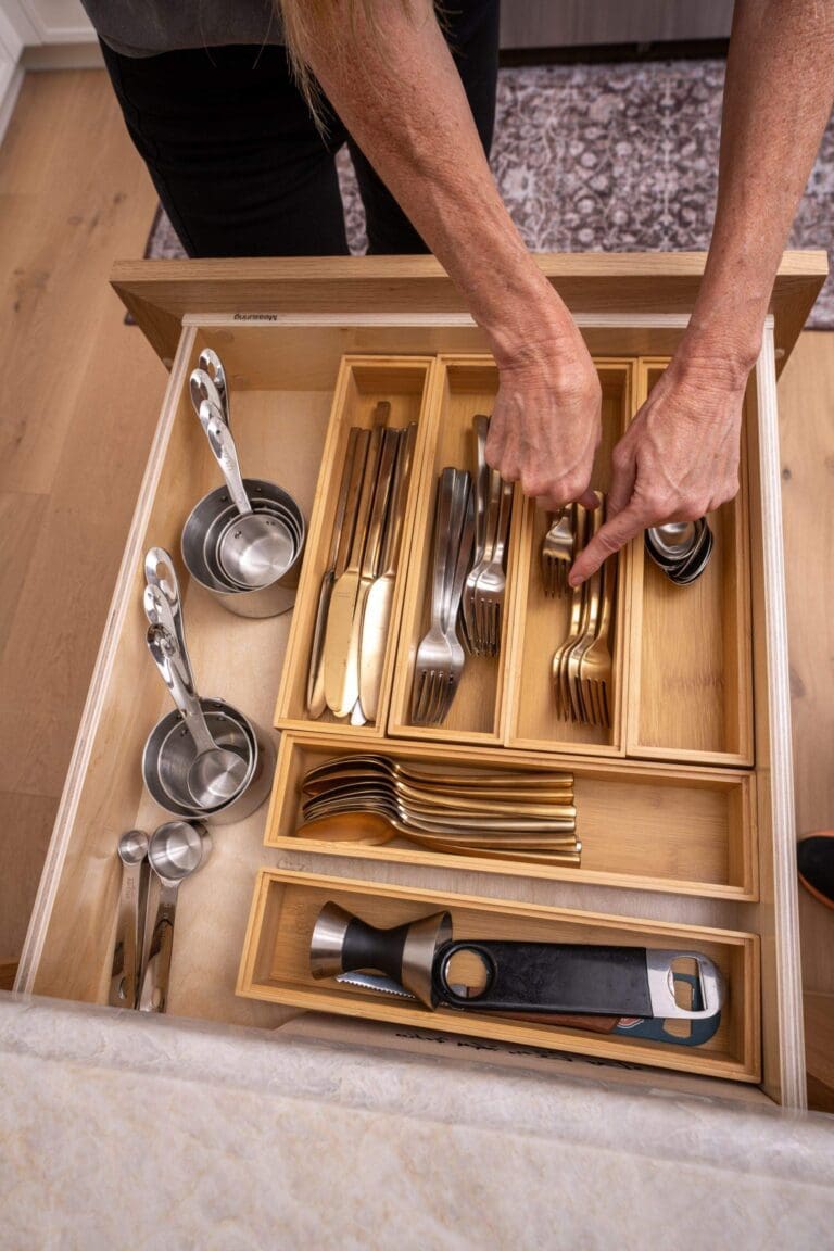 Organizer arranging silverware in a custom bamboo drawer insert with a section for every utensil