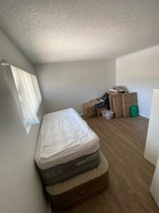 Guest room midway through unpacking, with the last few moving boxes in the corner