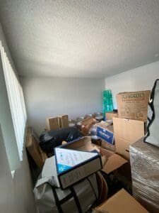 Guest room before unpacking, packed with moving boxes from wall to wall