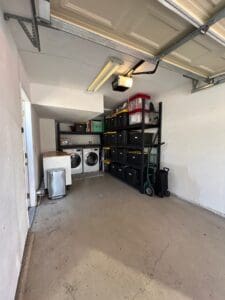Garage after decluttering, with the washer, dryer and shelving neatly organized