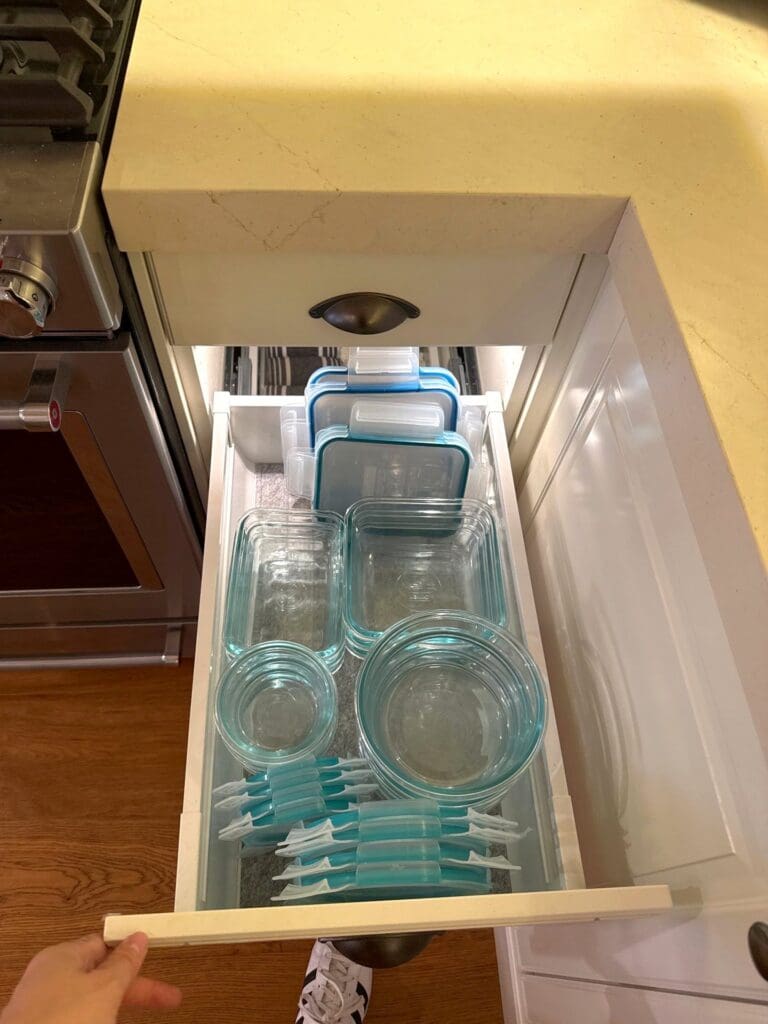 Kitchen drawer with nested airtight food storage containers and lids standing upright