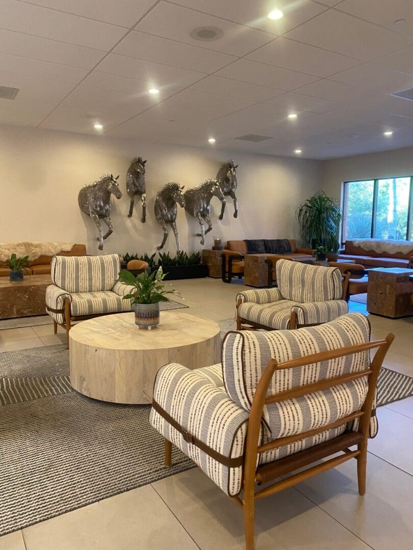 Cozy living room with striped chairs and horse wall art.