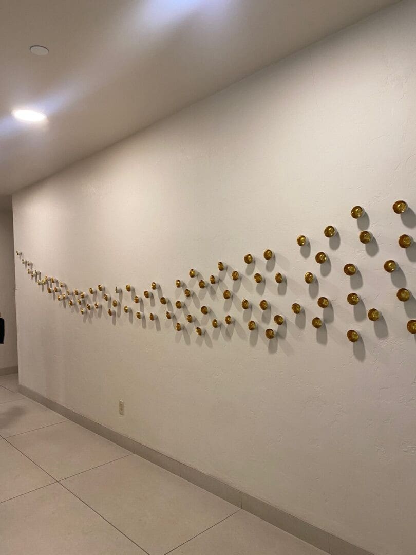 Wall decorated with a flowing pattern of circular golden elements.