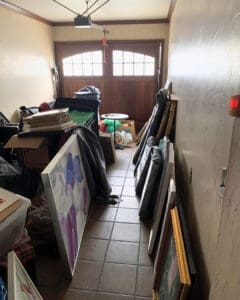 Framed art and furniture leaning along a hallway before packing, Newport Beach