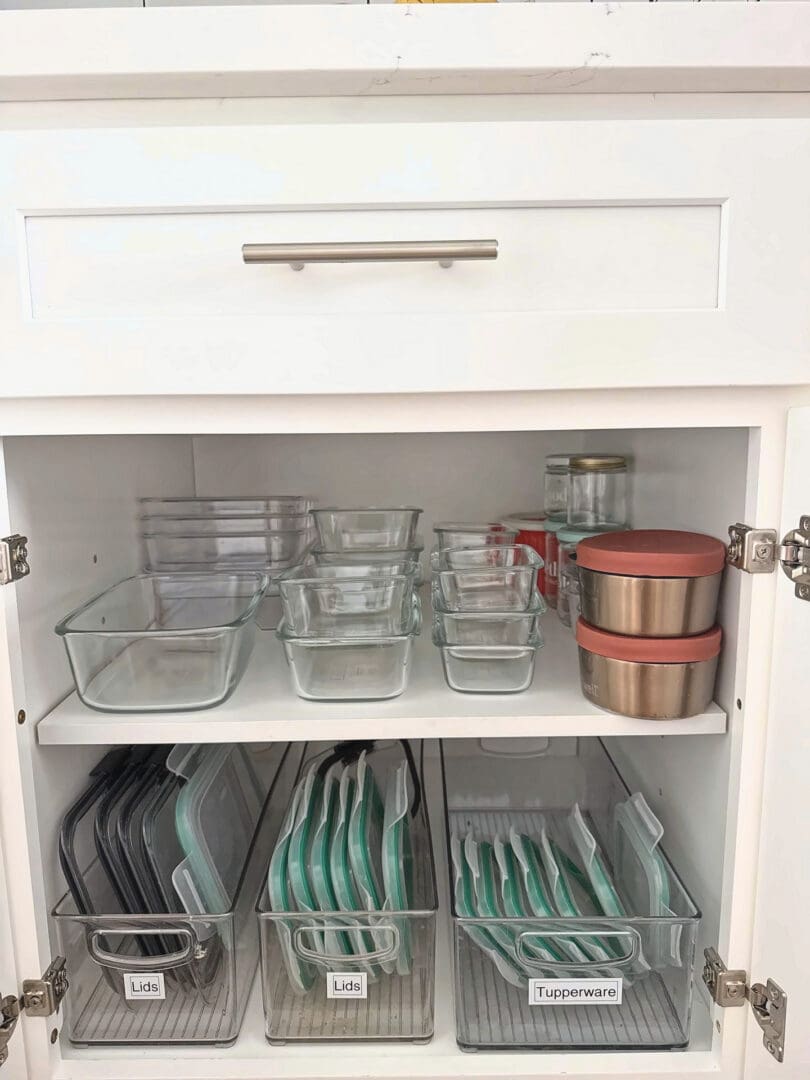 Organized kitchen cabinet with glass containers and labeled lid bins after Simply Luxe reset