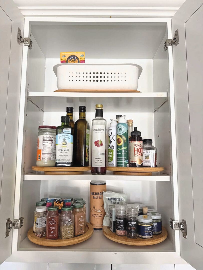 Organized spice and oils cabinet with lazy Susans after Simply Luxe reset