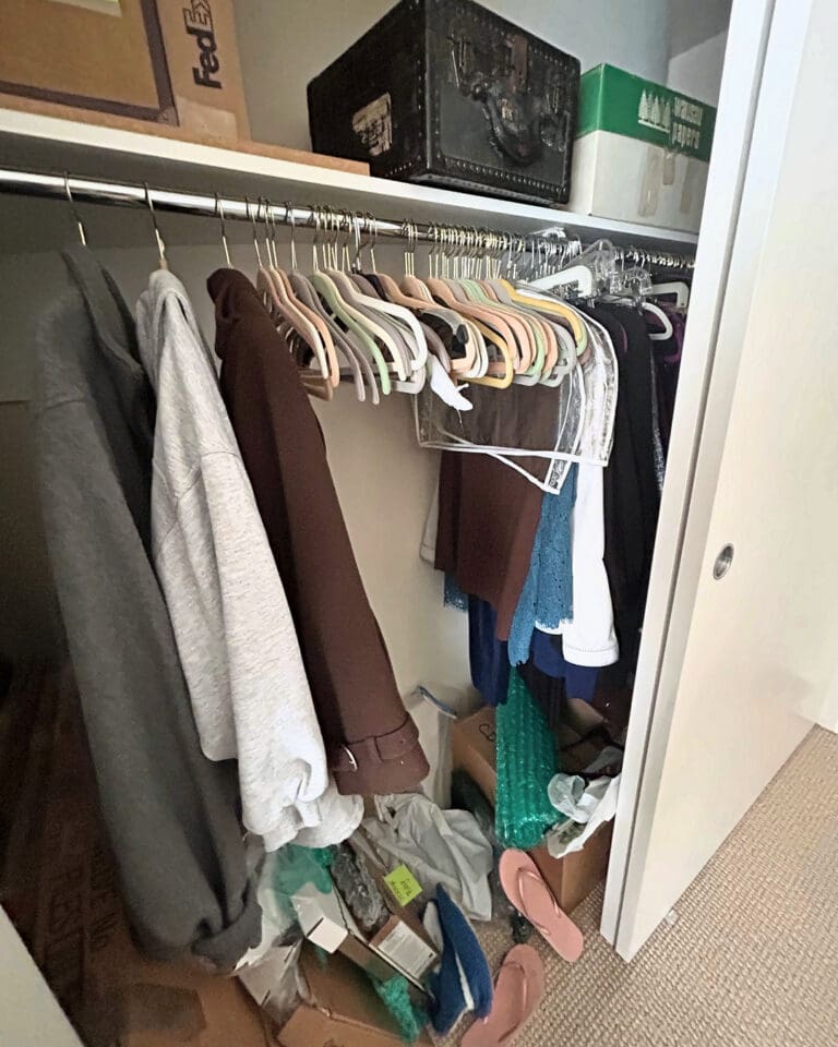 Crowded closet before packing, with clothes, bags and shoes piled on the floor, San Diego