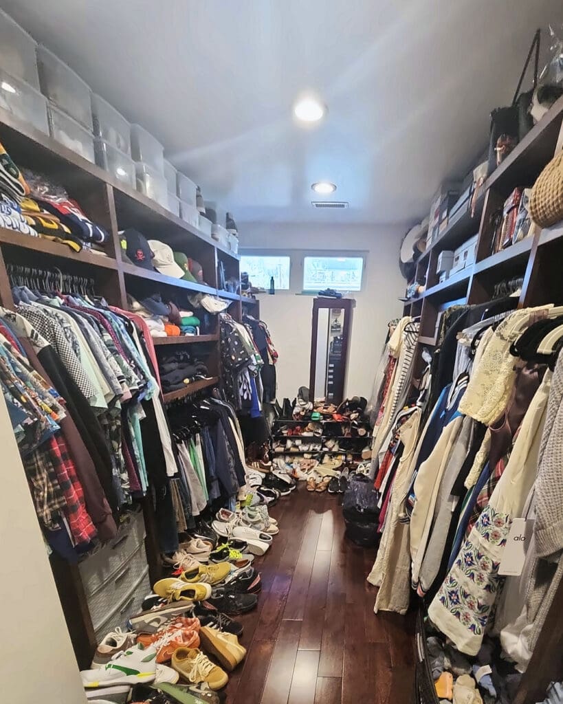 Walk-in closet before decluttering, with shoes piled across the floor and shelves packed tight, San Diego