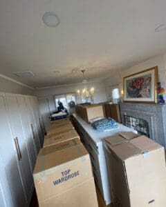 New closet room on moving day, lined with tall wardrobe boxes before unpacking, San Diego