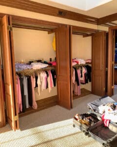Closets mid unpack, with rolling racks and suitcases being emptied, Newport Beach