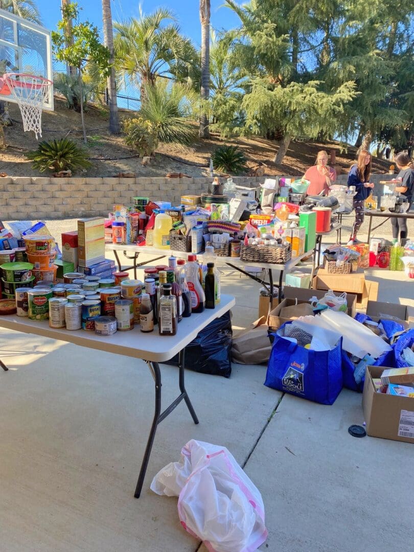 Before: a local family&rsquo;s pantry items pulled out and sorted on folding tables in the driveway during a Simply Luxe community give back