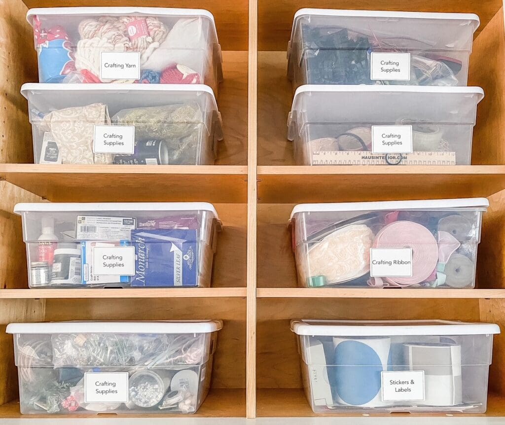 Labeled clear bins for yarn, ribbon and crafting supplies in warm wood cubbies