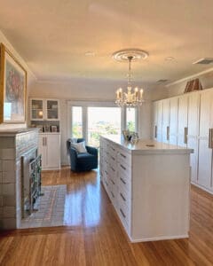 Finished custom closet room with white drawer island, chandelier and French doors to the harbor view, San Diego