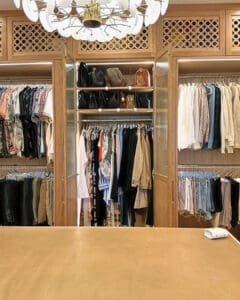 Custom closet after the Simply Luxe unpack, clothes hung by type under a chandelier, San Diego