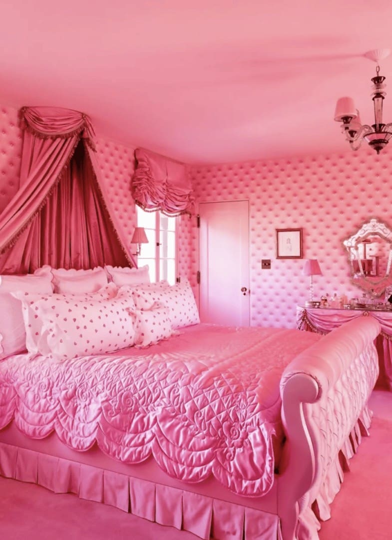Glamorous all-pink maximalist bedroom with tufted walls, canopy bed, and vanity in Eileen Kelly home organized by Simply Luxe