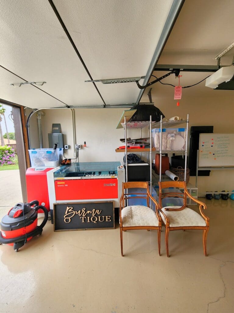Carlsbad garage after organizing, with a craft and sewing corner, two chairs and a shop vac parked by the machines