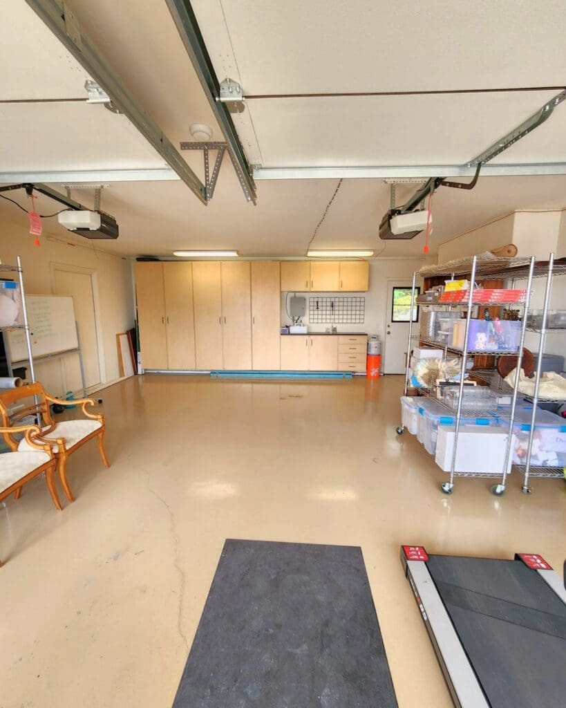 Same Carlsbad garage after organizing, with an open floor, wire shelving of labeled bins and the back wall cabinets clear