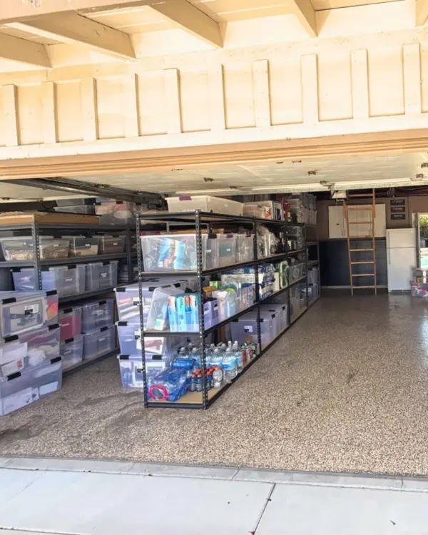 Same two car garage after Simply Luxe organizing, with clear bins sorted on rows of shelving and the floor open to the back wall, Santa Ana