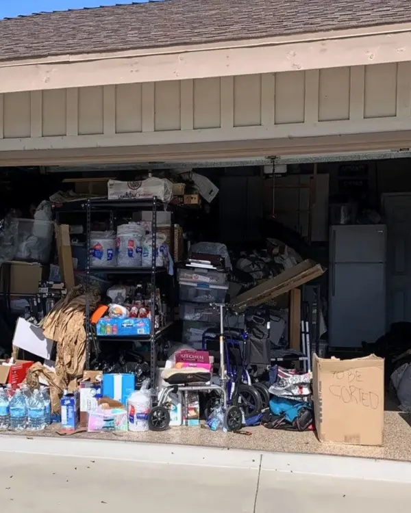 Two car garage before organizing, packed with boxes, bins, paper goods and loose items across the floor, Santa Ana home