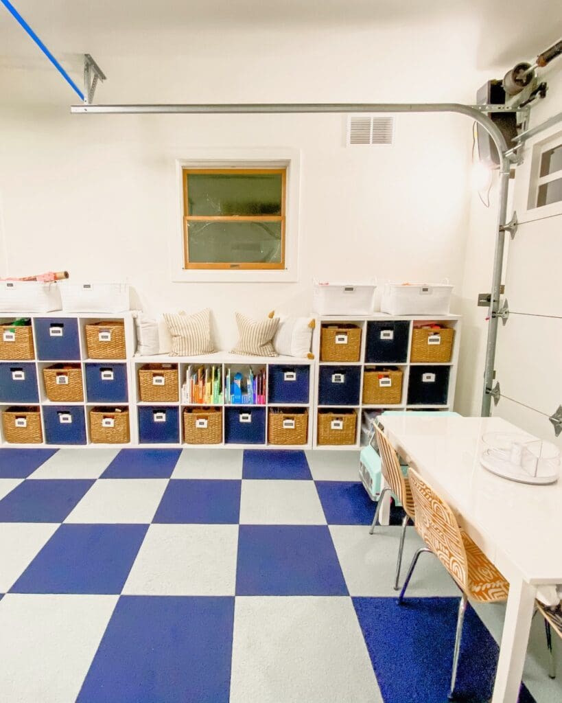 Same Solana Beach garage after, turned into a playroom with cube storage, navy and white floor tiles and a craft table