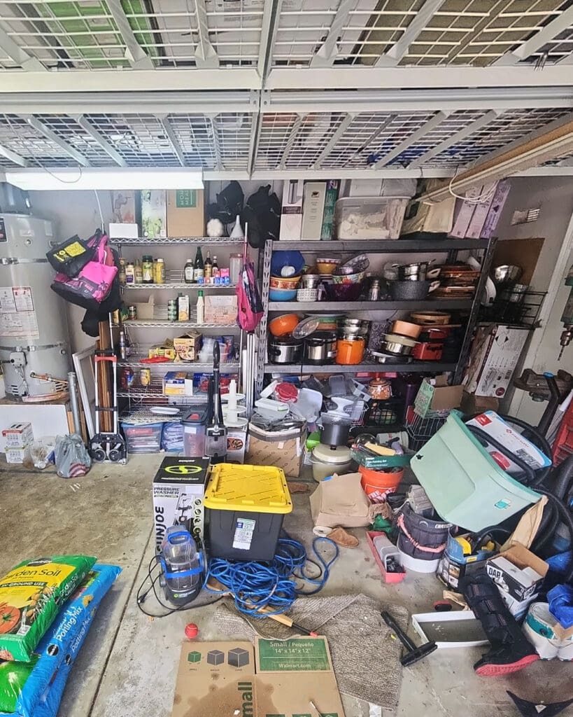 Garage before organizing, with overloaded shelves and tools, bins, hoses and bags of soil covering the floor, Chula Vista home