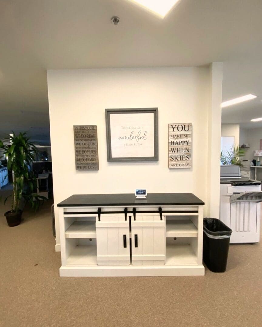 Office entry console before holiday decorating, with plain framed signs on a white wall