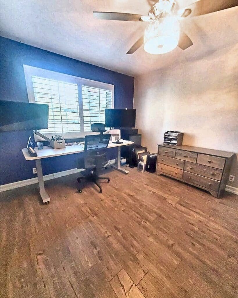 Home office after organizing, with two clear standing desks under the window and a tidy dresser for supplies