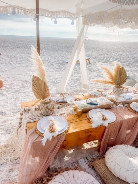 Elegant beachside wedding table setup with peach and beige tones.