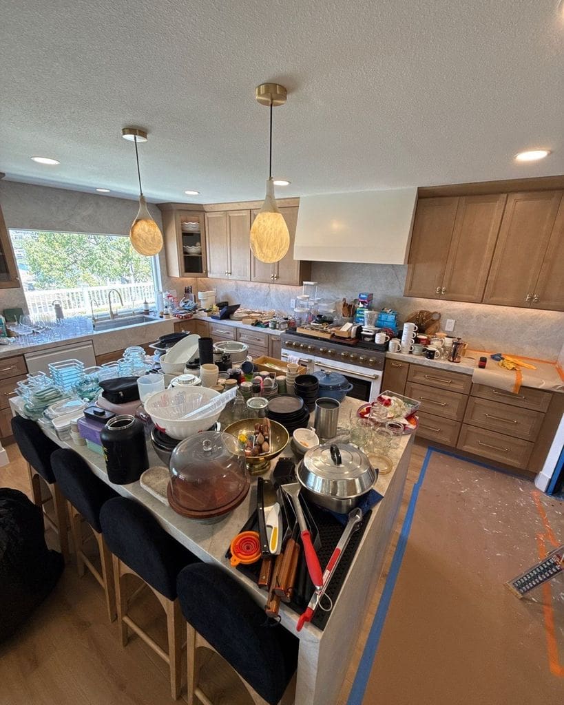 Kitchen island covered in boxes and dishes before unpacking after a flood remodel, Mission Viejo