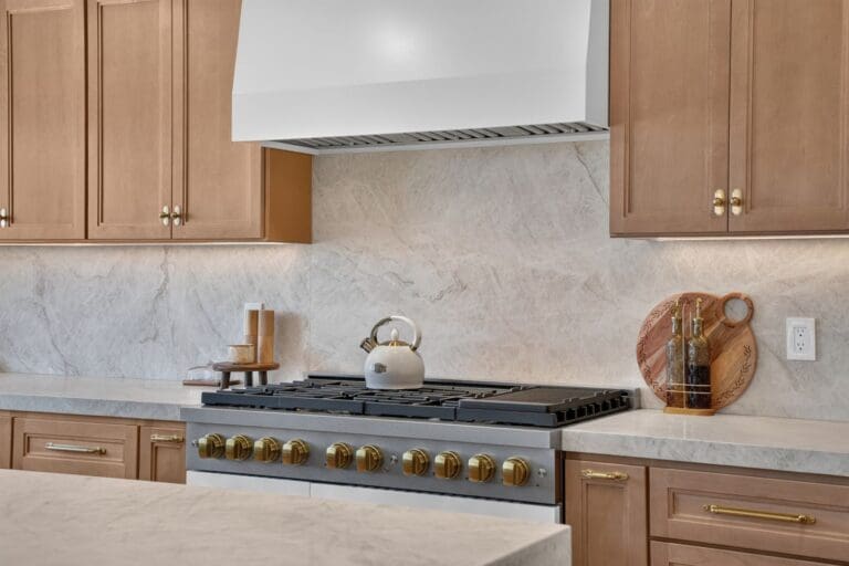 Remodeled kitchen range wall with marble backsplash and styled counters in Mission Viejo