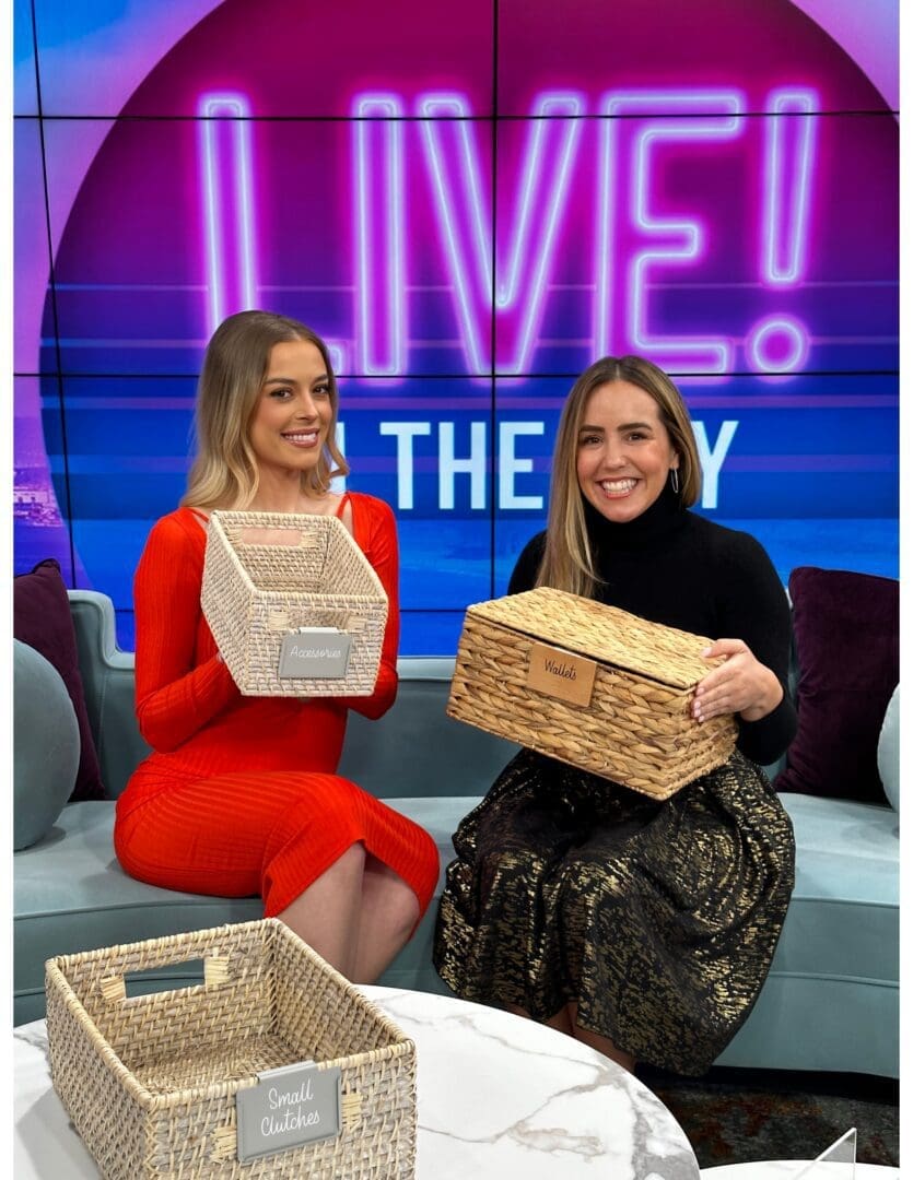 Live in the Bay two women showing baskets in the set of Live in the Bay