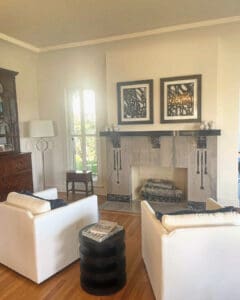 Living room set up after the move, with white sofas, art hung and the fireplace styled, Orange County