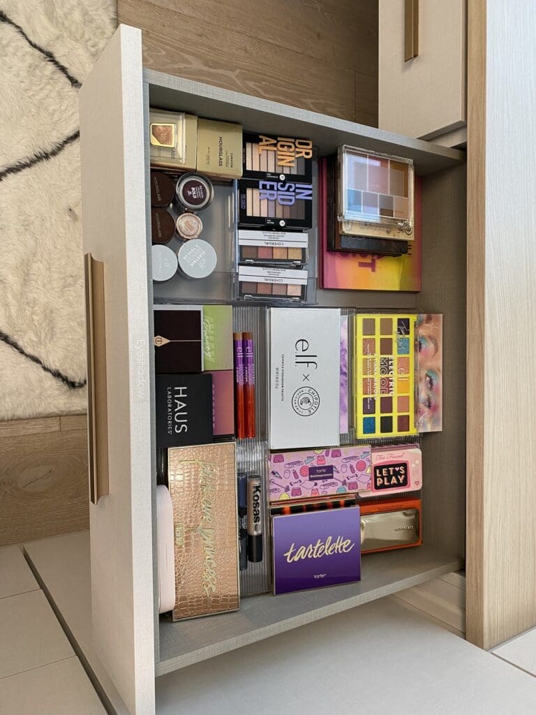 Makeup palettes standing upright in a pull-out cabinet in a La Jolla dressing room