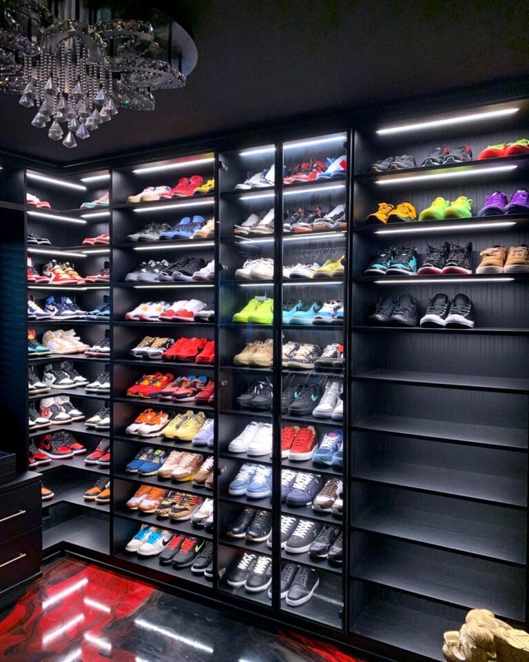 Same men's closet after Simply Luxe organizing, with sneakers lined on lit black shelves above a glossy red and black floor, Costa Mesa