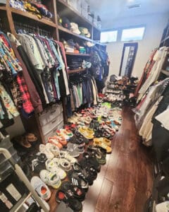 Walk-in closet before the declutter, with dozens of shoes across the floor, San Diego