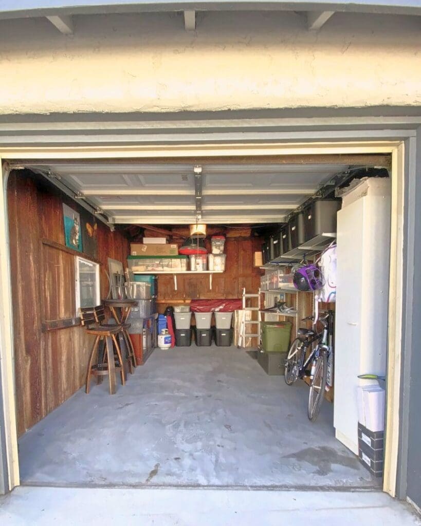 Same one car garage after Simply Luxe organizing, with bins on overhead and back wall shelves, a bike stored along the side and a clear floor, San Diego