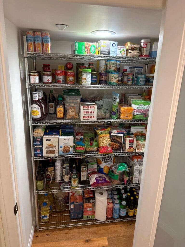 Organized walk-in pantry with grouped canned goods, snacks, and baking staples on shelves